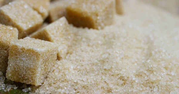 Makro laukaus koostumuksesta sokeriruo 'on, sokerikuutiot ja sokeri raaka rakeita. Konsepti: makeutusaine, luonto, energia, mehut ja juomat . — kuvapankkivalokuva