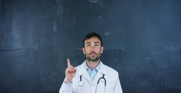 The portrait of the professor, the doctor (student) stands at the black board, on a black background. Concept: ideas, professions, university, chemistry, science teachers memory biology doctor college — Stock Photo, Image