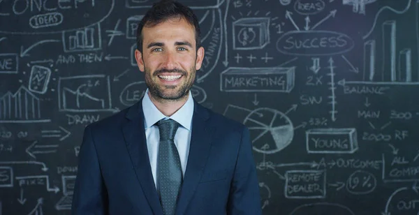 Retrato de um homem de negócios, um professor de marketing, desenha um gráfico de sucesso em uma placa preta, em um fundo preto. O conceito: crescimento da carreira, gráfico de crescimento, homem de sucesso, marketing, ideias, finanças . — Fotografia de Stock
