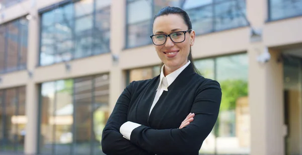 Uma mulher de fato, olha para a câmara e sorri orgulhosa e segura de si mesma, no centro de negócios. Conceito de política, negócios, finanças, bancos, seguros e depoimentos para campanha política . — Fotografia de Stock