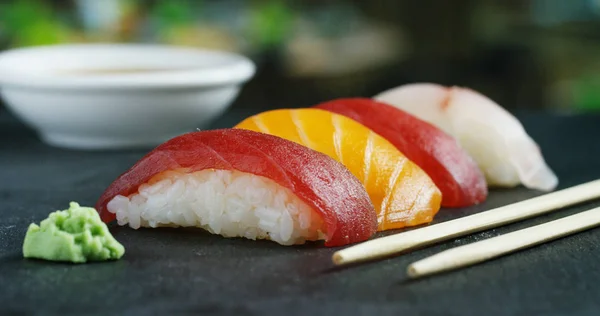 Macro-opname van sushi, sashimi, uramaki en nighiri. typisch Japans gerecht bestaande uit rijst, zalm of tonijn, garnalen en vis eieren gedrenkt in soja. Concept: Sushi, Japans restaurant, oosterse traditie. — Stockfoto