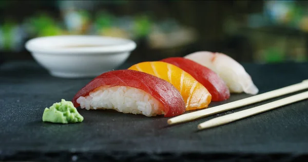 Macro-opname van sushi, sashimi, uramaki en nighiri. typisch Japans gerecht bestaande uit rijst, zalm of tonijn, garnalen en vis eieren gedrenkt in soja. Concept: Sushi, Japans restaurant, oosterse traditie. — Stockfoto