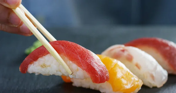 Macro-opname van sushi, sashimi, uramaki en nighiri. typisch Japans gerecht bestaande uit rijst, zalm of tonijn, garnalen en vis eieren gedrenkt in soja. Concept: Sushi, Japans restaurant, oosterse traditie. — Stockfoto