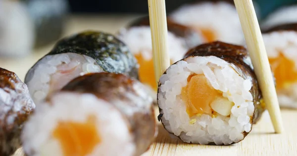 Macro-opname van sushi, sashimi, uramaki en nighiri. typisch Japans gerecht bestaande uit rijst, zalm of tonijn, garnalen en vis eieren gedrenkt in soja. Concept: Sushi, Japans restaurant, oosterse traditie. — Stockfoto