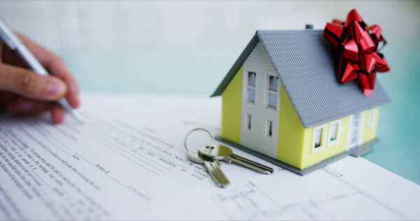 страхование от пожара и кражи. Руки страховщика или агента по недвижимости, показывающего дом с планом этажа и документы с гарантированными ключами от дома. концепция дома, семьи, страховки. аренда дома
