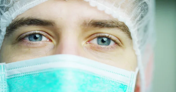 Närbild porträtt av en kirurg eller läkare med mask och headsetet redo för operation på sjukhus eller klinik. Kirurgen leenden trygg och stolt över sig själv. Begreppet medicin, sjukhus och läkare, vård — Stockfoto