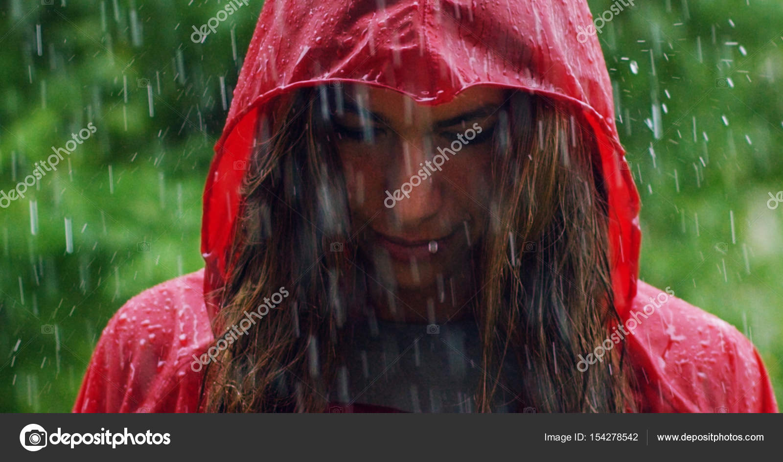 Girl smiles and laughs in the rain. the rain falls, the drops fall on his  face