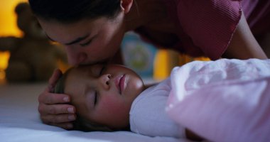 Bebek mutlu ve kaygısız uyuyor, anne öpücüğü iyi geceler okşadı. ev ve ev kavramı. gece ve mutlu rüyalar, hiçbir sivrisinekler, hiçbir gürültülü ev ve rahat yatakları. rahat çocuk