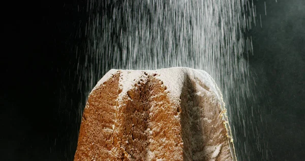 Primo piano di un Pandoro, una tipica pasticceria italiana mangiata durante le feste natalizie e il nuovo anno, lo zucchero a velo cade al rallentatore su Pandora creando la magia natalizia . — Foto Stock