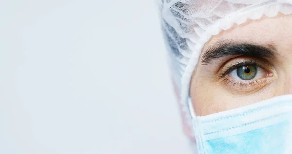 Portret van een chirurg of arts met masker en headset gereed voor gebruik in het ziekenhuis of de kliniek close-up. De chirurg glimlacht veilig en trots op zichzelf. Concept van geneeskunde, ziekenhuizen en artsen, zorg — Stockfoto