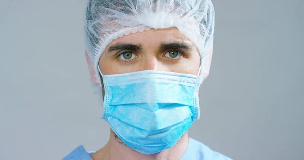 Close up portrait of a surgeon or doctor with mask and headset ready for operation in hospital or clinic. The surgeon smiles safe and proud of himself. Concept of medicine, hospitals and doctors, care — Stock Photo, Image