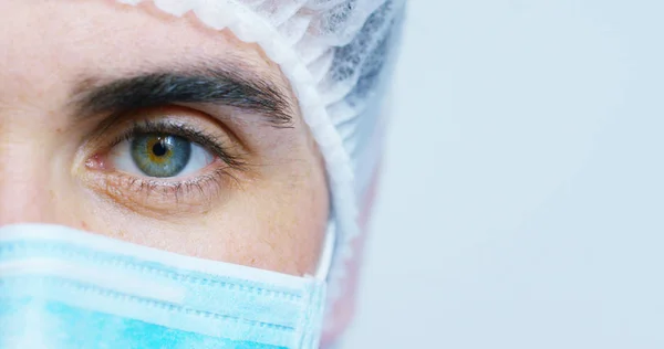 Ritratto ravvicinato di un chirurgo o di un medico con maschera e auricolare pronti per l'operazione in ospedale o in clinica. Il chirurgo sorride sicuro e orgoglioso di sé. Concetto di medicina, ospedali e medici, cure — Foto Stock