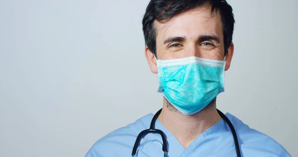 Portret van een chirurg of arts met masker en headset gereed voor gebruik in het ziekenhuis of de kliniek close-up. De chirurg glimlacht veilig en trots op zichzelf. Concept van geneeskunde, ziekenhuizen en artsen, zorg — Stockfoto
