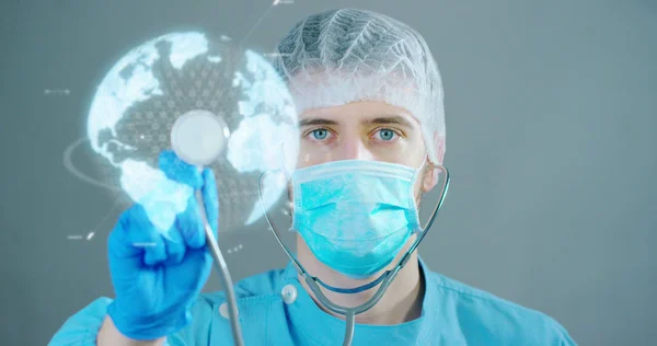 Ein futuristischer Arzt zeigt Stethoskop und die Darstellung futuristischer Medizin-Symbole in der Holographie. Konzept: Zukunft, Medizin, Herz, Krankheit und Pflege sowie globale Gesundheitsfürsorge und Leben. — Stockfoto