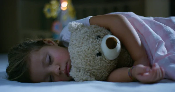 Baby vilar tyst i sängen kramas en nallebjörn leksak, begreppet fredliga drömmar och bostäder utan att buller, glada barn och mamma och pappa glad. lycka i sömn, barn utan hosta. — Stockfoto