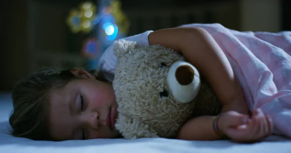 Baby rests quietly in bed hugging a teddy bear toy, concept of peaceful dreams and homes without noise, happy children and mom and dad happy. happiness in sleep, children without coughing. — Stock Photo, Image