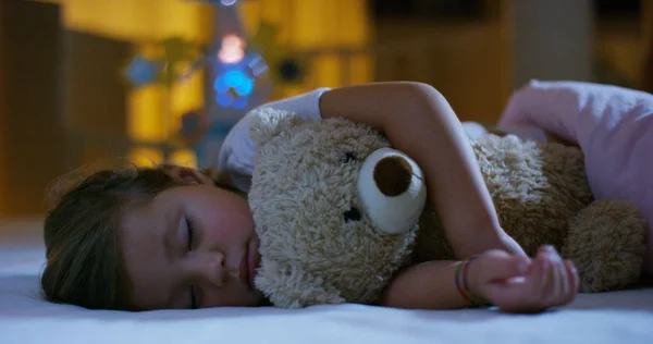 Bebé descansa tranquilamente en la cama abrazando un juguete de oso de peluche, concepto de sueños pacíficos y hogares sin ruido, niños felices y mamá y papá felices. felicidad en el sueño, niños sin toser . —  Fotos de Stock