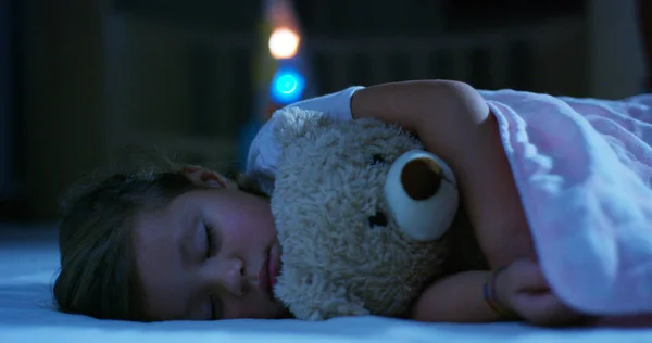 Baby vilar tyst i sängen kramas en nallebjörn leksak, begreppet fredliga drömmar och bostäder utan att buller, glada barn och mamma och pappa glad. lycka i sömn, barn utan hosta. — Stockfoto