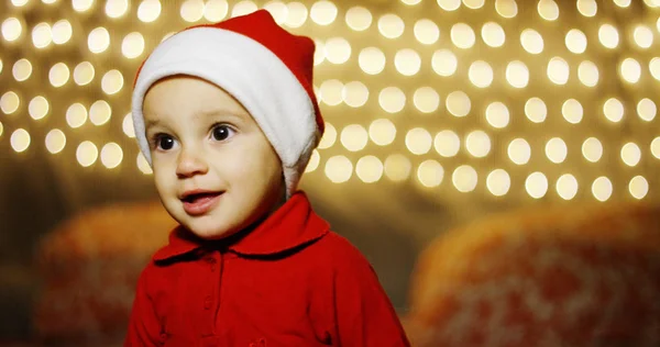 Baby spielt mit einem funkelnden Lächeln der Freude für das neue Jahr, sie freuen sich auf die Weihnachtszeit. Warten auf den Weihnachtsmann Liebe für das Weihnachtsfest und die Familie zusammen. Stockfoto