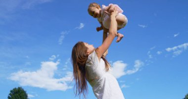 Aile mutlu güneşli bir gün, anne ve bebek küçük bir kız oynamak ve renkli doğada dalmış mutluyuz ve mutluluk, Bebek mutlu gülüyor. mutluluk, aşk ve doğa kavramı.