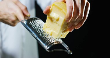Aşçı rende Parmesan peyniri, ağır çekim, tipik İtalyan peyniri, Taze demlenmiş sadece tabakta. Konsept: İtalyan mutfağı, peynir, Restoran ve gıda.