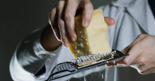 Медленное движение терки пармезан сыр, типичный итальянский сыр, на тарелке только что сваренный. Концепция: итальянская кухня, сыр, ресторан и еда . — стоковое фото