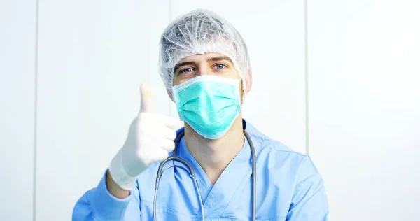 Ritratto ravvicinato di un chirurgo o di un medico con maschera e auricolare pronti per l'operazione in ospedale o in clinica. Il chirurgo sorride sicuro e orgoglioso di sé. Concetto di medicina, ospedali e medici, cure — Foto Stock