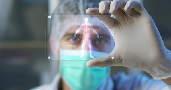 A physician, surgeon, examines a technological digital holographic plate represented the patient's body, the heart lungs, muscles, bones. Concept: Futuristic medicine, the human body, and the future. — Stock Photo, Image