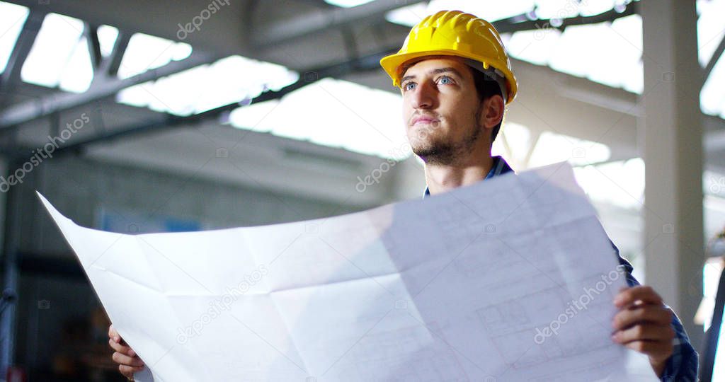 on a construction site, a worker or an engineer or architect controls the design and construction of the building with high energy savings. Concept: construction, worker, engineering, design.