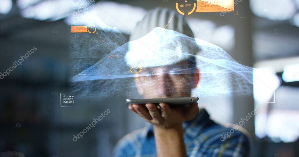 A worker uses a future technology platform to verify the design in holography and augmented virtual reality. Concept: future technology, multimedia technology, futuristic engineering.