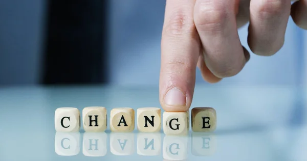 Junge Geschäftsmann Hand schafft das Wort "Veränderung" der hölzernen Buchstaben Blöcke. Konzept des Finanzmarktes und Zukunft des Börsengeschäfts. — Stockfoto