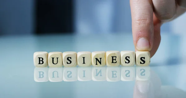 Young businessman hand creates the word "Business" of the wooden letter blocks . Concept of financial market and future of stock market business. — Stock Photo, Image
