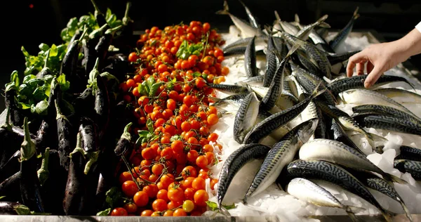 Movimento lento de tomates cereja que caem em um prato com peixe e berinjela (close-up ) — Fotografia de Stock