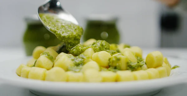 Super lenta macro movimento de servir nhoque com molho pesto no prato (close-up ) — Fotografia de Stock