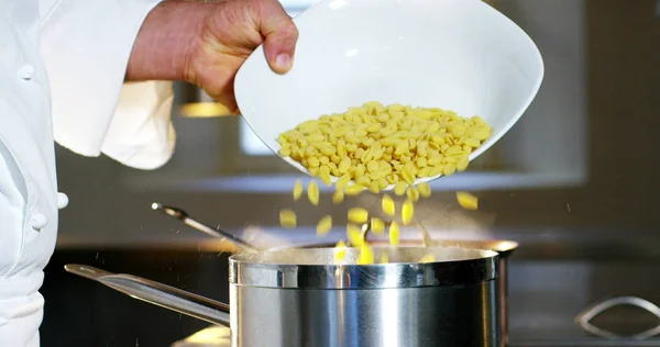 V italské kuchyni profesionální kuchař nasype sůl na misky nebo do vody k varu italské těstoviny koncepce zdravé a lehké jídlo. Bio — Stock fotografie