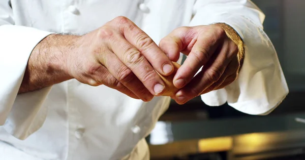 En una cocina profesional italiana un chef vierte sal en un plato o en el agua para hervir el concepto de pasta italiana de comida sana y ligera. biografía —  Fotos de Stock