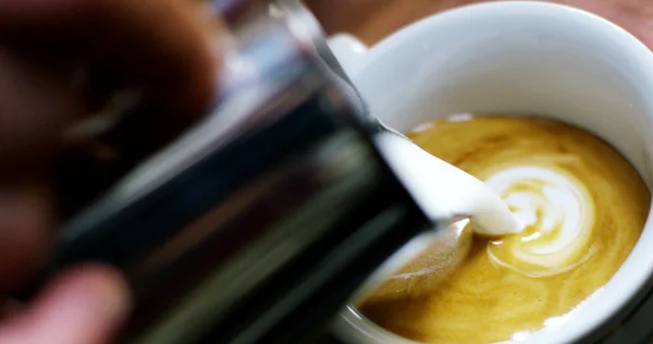 Een barman maakt een artistieke samenstelling met verse melk om een cappuccino Italiaanse kwaliteit, met behulp van Italiaanse espresso. Italiaanse concept, passie voor werk, Ontbijt en liefde voor koffie en kunst. — Stockfoto