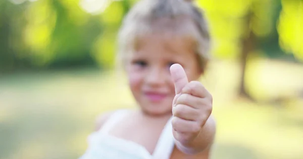 Cantik dan sehat bayi perempuan mengangkat jempol jari untuk persetujuan. persetujuan konsep, alam dan keberlanjutan. hijau dan koneksi di seluruh dunia — Stok Foto