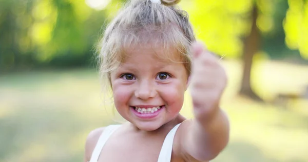 Schönes und gesundes kleines Mädchen hebt zustimmend den Daumen. Konzeptabstimmung, Natur und Nachhaltigkeit. Grün und Verbindungen weltweit — Stockfoto