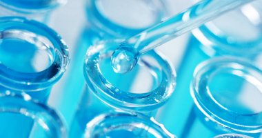 Bir laboratuarda, pipetli bir bilim adamı test tüplerindeki DNA ve molekülleri ayırmak için renkli bir sıvıyı analiz eder. Konsept: araştırma, biyokimya, doğa, ilaç