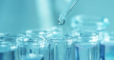 Bir laboratuarda, pipetli bir bilim adamı test tüplerindeki DNA ve molekülleri ayırmak için renkli bir sıvıyı analiz eder. Konsept: araştırma, biyokimya, doğa, ilaç