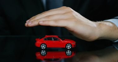 Bir takım elbise ve kravat, giymiş bir adam küçük bir otomatik gösterir. Konsept: araba sigortası, mekanik, Finansal Kiralama, satın yeni ve kullanılmış otomobil ve ortak garajlar.