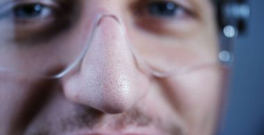 Bir laboratuvarda bir bilim adamı ile gözlük ve maske mavi gözlü kameraya benziyor. Konsept: araştırma, biyokimya, doğa, ilaç tıp ve bilim