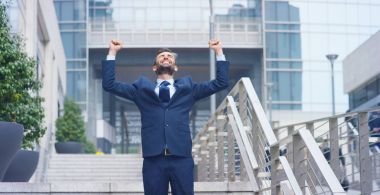 Gökdelenler arasında hücre, baktıktan sonra bir işadamı sevinir ve zafer veya promosyon için dans etmeye başlar. Konsept: bahis, finans, ekip çalışması, dans ve kariyer