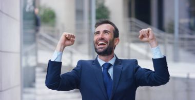 Gökdelenler arasında hücre, baktıktan sonra bir işadamı sevinir ve zafer veya promosyon için dans etmeye başlar. Konsept: bahis, finans, ekip çalışması, dans ve kariyer