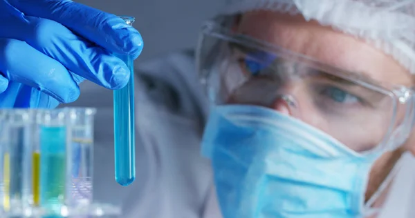 En un laboratorio, un científico con una pipeta analiza un líquido de color para extraer el ADN y las moléculas en los tubos de ensayo. Concepto: investigación, bioquímica, naturaleza, medicina farmacéutica —  Fotos de Stock