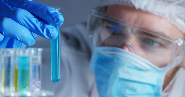 Em um laboratório, um cientista com uma pipeta analisa um líquido colorido para extrair o DNA e as moléculas nos tubos de ensaio. Conceito: pesquisa, bioquímica, natureza, medicina farmacêutica — Fotografia de Stock