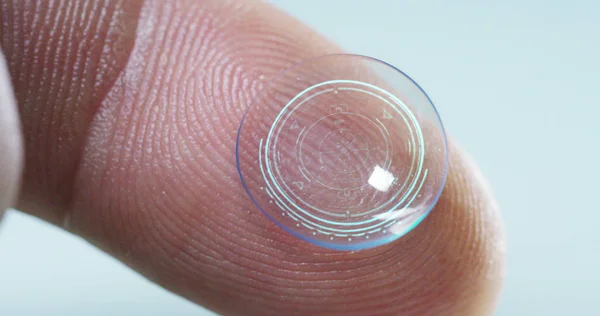Makro szemcsésedik-ból egy ujj holding a kontaktlencse technológia-val egy chip, hogy jobb a szeme és a növekedés dioptria. Koncepció: szemvizsgálat, optikai, magával ragadó technológia — Stock Fotó