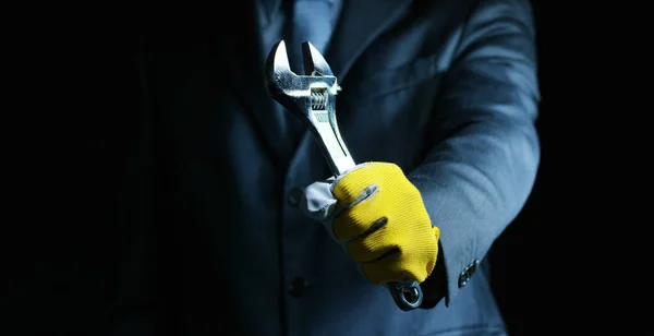 Ένας άντρας ντυμένος με κοστούμι και γραβάτα, δείχνοντας ένα μηχανικό κλειδί. Έννοια: ασφάλιση αυτοκινήτων, μηχανικό, χρηματοδοτικής μίσθωσης — Φωτογραφία Αρχείου