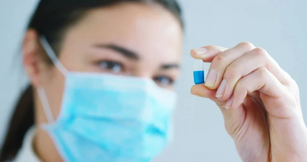 La mano de una mujer experta en medicina del hospital muestra el medicamento que debe tomar el paciente en cámara lenta . — Foto de Stock